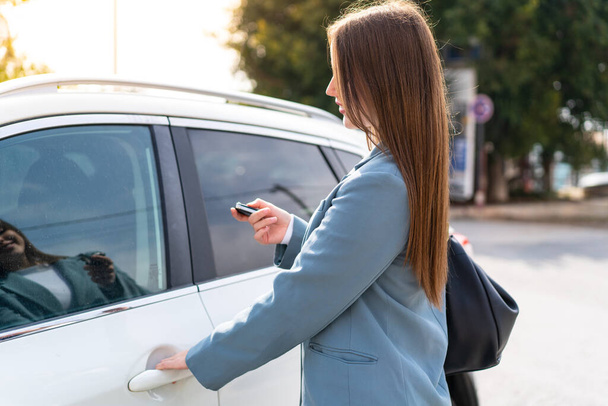 Mladá hezká žena drží klíče od auta venku - Fotografie, Obrázek