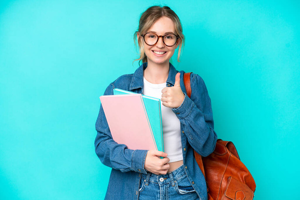 Young student woman isolated on blue background giving a thumbs up gesture - Photo, Image