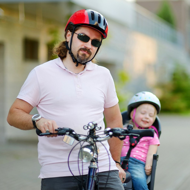 Молодые отец и дочь на велосипеде
 - Фото, изображение