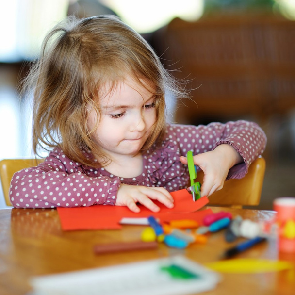 Preschooler girl cutting paper - Fotó, kép