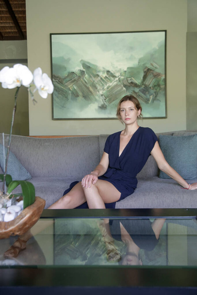 Elegante mujer de moda sentada en el sofá. Estilo de vida doméstico de lujo. - Foto, imagen