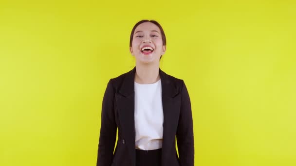 Portret pięknej businesswoman w garniturze stoi zadowolony i sukces odizolowany na żółtym tle, młoda azjatycka kobieta biznesu jest menedżer lub wykonawczy uśmiech z pewnością i podekscytowany do zwycięstwa. - Materiał filmowy, wideo