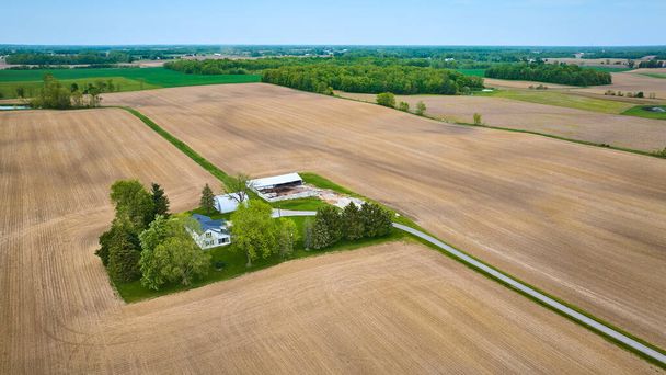 Imagen de Aerial clean farmhouse landscape property aerial with green runoff ditch, paved road, empty fields - Foto, Imagen