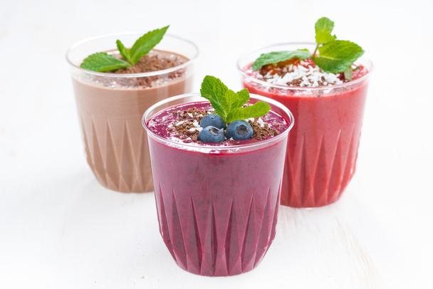 blueberry, chocolate and strawberry milkshakes in glasses - Foto, afbeelding