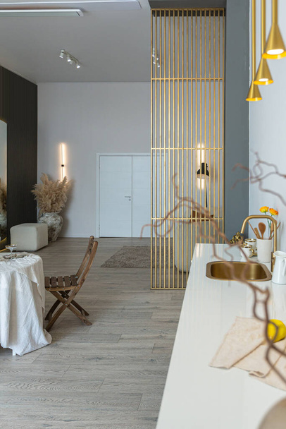 romantikus asztal szolgál két fő részére a konyhában egy világos, nyitott terű apartman modern stílusban, világos falak és fapadló. - Fotó, kép