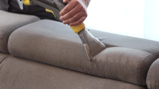 Cleaning concept. Woman washes soft furniture in living room. Employee removing dirt from furniture, closeup - Footage, Video