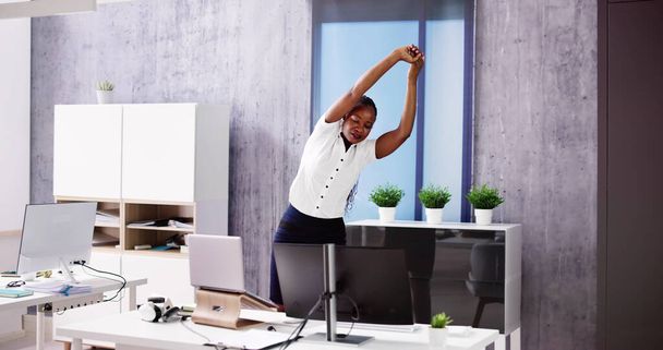 Arms Stretch Exercise Standing Near Desk In Office - Фото, зображення