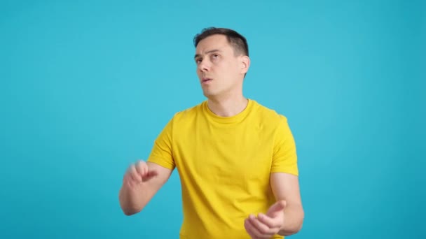 Video in studio con sfondo blu di un uomo scontento e deluso che applaude ironicamente alla telecamera - Filmati, video