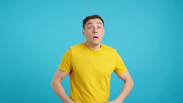 Video in studio with blue background of a man with a cold sneezes five times in a row - Footage, Video