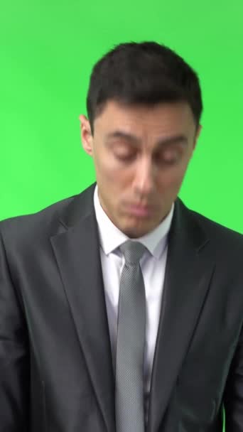 Κουρασμένος άνδρας με κομψό γκρι κοστούμι κοιτάζει μακριά με νυσταγμένο πρόσωπο ενώ στέκεται απομονωμένος στο κλειδί chroma στο στούντιο φωτός - Πλάνα, βίντεο