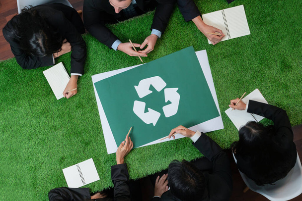 Panorama-Banner Recycling-Symbol von oben auf dem Besprechungstisch im Büro mit Geschäftsleuten, die Öko-Investitionen in die Abfallwirtschaft planen, da Recycling das Wiederverwendungskonzept für ein sauberes Ökosystem reduziert. Urig - Foto, Bild