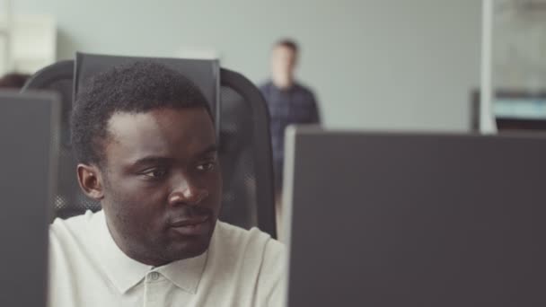 Δύο νέοι πολυεθνικοί άνδρες προγραμματιστές συζητούν για το λογισμικό ενώ συνεργάζονται στο σύγχρονο γραφείο - Πλάνα, βίντεο