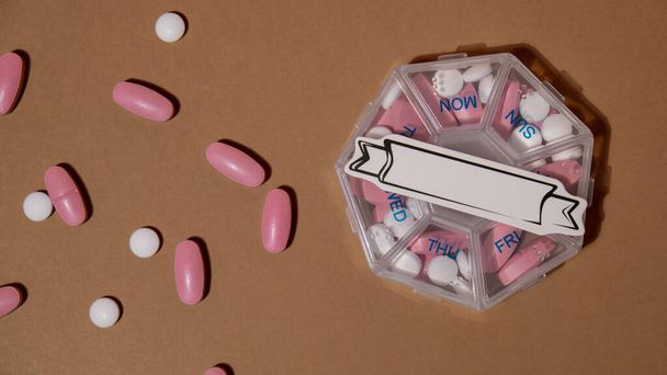 Closeup of medical pill box with doses of tablets for daily take medicine with white pink drugs and capsules with paper note Copy space for your text template mock up. Daily vitamins at home - Valokuva, kuva