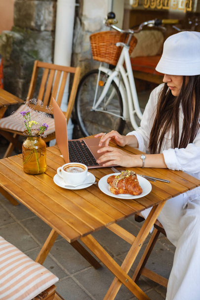 woman works on laptop in cafe on summer playground - Photo, Image