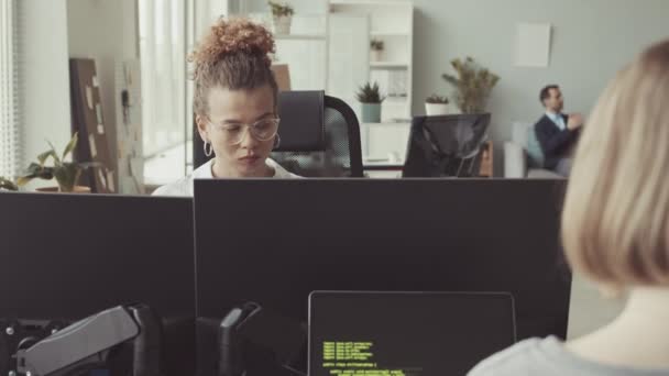 若い白人女性は,多様な同僚と明るい現代ITオフィスでコンピュータに取り組んでいます - 映像、動画