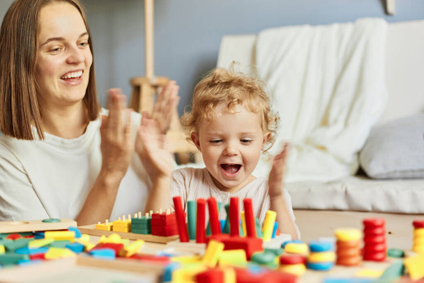 Cognitive puzzle challenges. Happy family gatherings. Parenting adventures together. Teacher or mother playing with baby with logical toys at home interior - Φωτογραφία, εικόνα