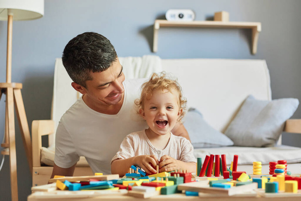 Imaginative storytelling games. Cognitive puzzle challenges. Montessori teaching method. Baby girl playing sorter with her father in living-room. - Foto, Imagem