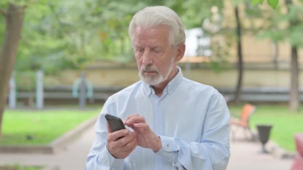 Senior Old Man Browsing Internet on Smartphone Outdoor - Video