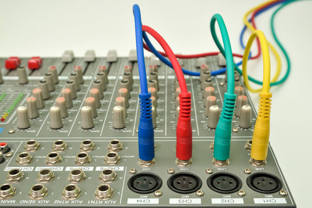 Zene keverő konzol csatlakoztatott audio jack csatlakozókkal. Különböző színek audio kábelek csatlakoztatására és rögzítésére hangszer. - Fotó, kép