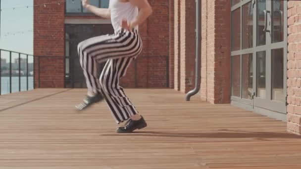 Fantasia ragazzo in pantaloni vintage a righe e berretto voguing all'aperto sulla terrazza - Filmati, video