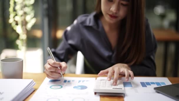 propietario de negocios o comercializadoras asiáticas están utilizando la calculadora para calcular y mantener la pluma punto a documento de presupuesto en el trabajo de oficina. Imágenes de alta calidad 4k - Imágenes, Vídeo