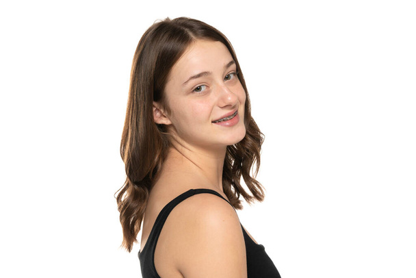 beautiful smiling young women with long hair, no makeup and dental braces on a white studio background. - Photo, Image