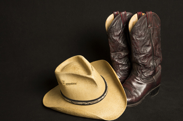 botas de cowboy e chapéu de cowboy no fundo preto
 - Foto, Imagem