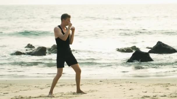 молодий чоловік бореться з тіні на узбережжі океану. Високоякісні відеозаписи 4k - Кадри, відео