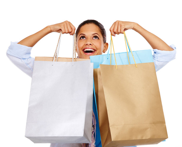 Woman, shopping bags and smile for store sale, discount or deal against white studio background. Happy isolated female shopper smiling holding gift bags for retail shopping spree on white background. - Photo, image