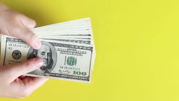 One hundred dollar bills on a yellow background. Winning the lottery or making money. Successful investment of money, receiving rewards - Footage, Video