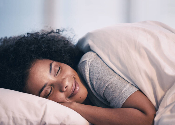Sleeping, woman and smile in bed with morning nap at home with rest feeling calm with peace. House, bedroom and tired female person relax and comfortable on a pillow with blanket dreaming on weekend. - Photo, Image