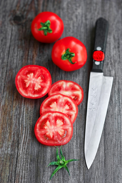 Sliced tomatoes on wooden table - Photo, image