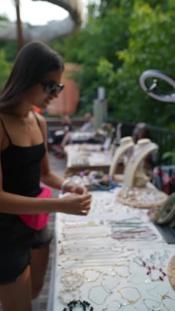Une bague faite à la main est installée par la jeune fille sur le marché artisanal. Des images FullHD de haute qualité - Séquence, vidéo