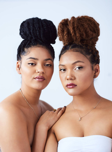 Theyre both ravishing beauties. Studio shot of two beautiful young women posing against a grey background - Foto, imagen