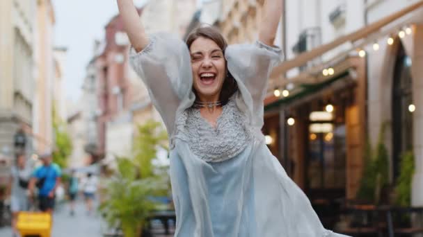 Portrait of young woman shouting, celebrating success, winning, goal achievement, good news, lottery jackpot luck, victory outdoors. Lovely pretty girl walking in urban city street. Town lifestyles - Footage, Video
