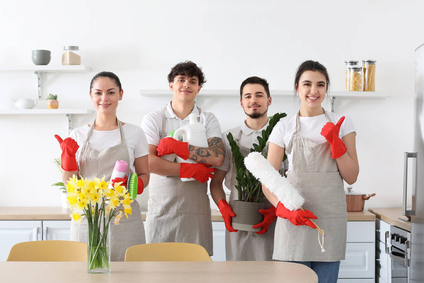Νεαροί καθαριστές με καθαριστικά και οικιακές εγκαταστάσεις στην κουζίνα - Φωτογραφία, εικόνα