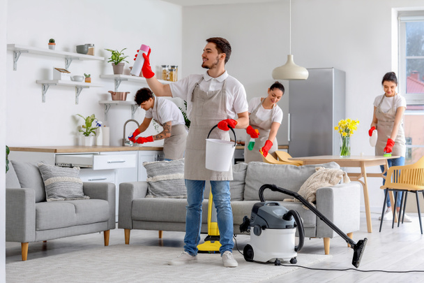 Young janitors cleaning in kitchen - Foto, Bild