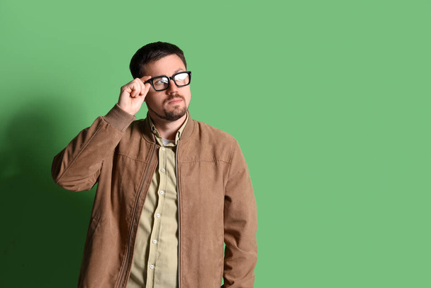 Przystojny mężczyzna w stylowych okularach na zielonym tle - Zdjęcie, obraz