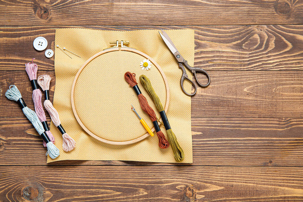 Koruompelulanka kangas, sakset ja mouline kierteet ruskea puinen tausta - Valokuva, kuva