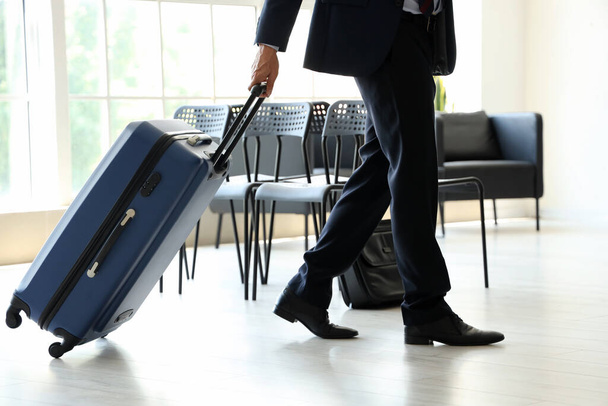 Hombre de negocios maduro con maleta caminando en el pasillo del aeropuerto - Foto, Imagen