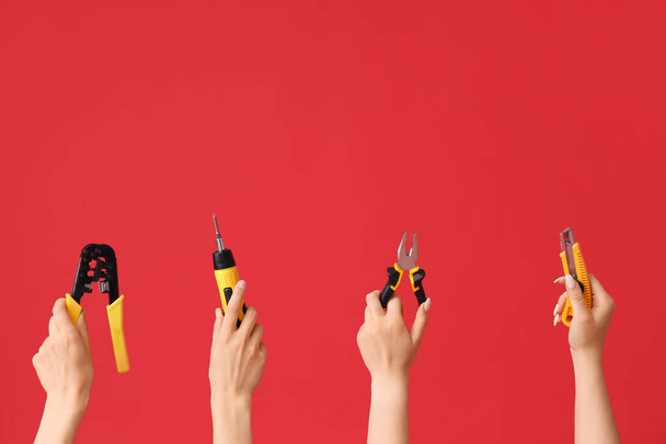 Electrician hands with tools on red background - Photo, Image