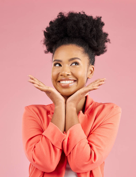 Fashion, beauty and thinking with an afro woman in studio isolated on pink background for trendy style. Smile, hair and idea with a happy or confident young african person posing in a clothes outfit. - Foto, Imagem