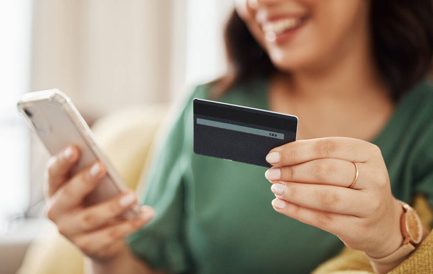 Phone, credit card closeup and woman hands with online shopping and banking at home. Ecommerce, mobile cashback and sale with digital payment and easy pay with discount and smile from web checkout. - Photo, Image