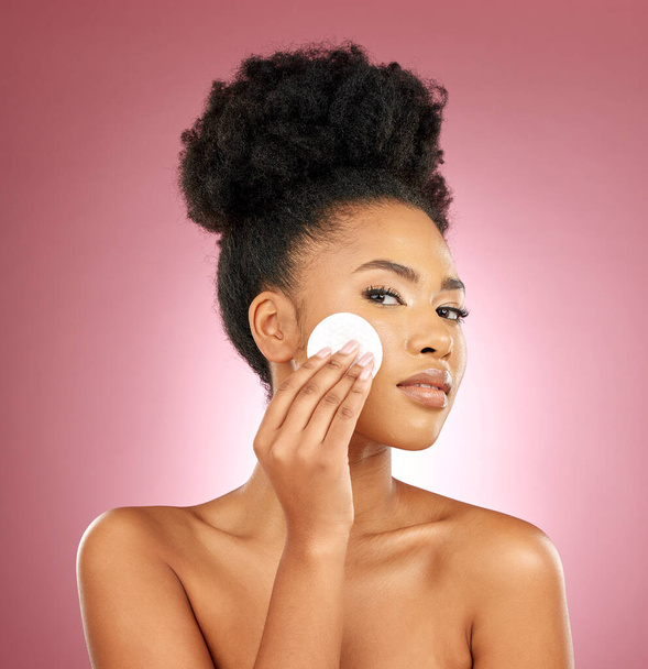 Black woman, cotton pad and portrait with makeup, dermatology and skincare on a studio background. Female person, shine and model with cosmetics, aesthetic and cleaning with beauty, glow and patches. - Photo, Image