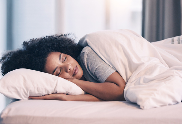 Sleeping, woman and bed with nap at home in morning with rest feeling calm with peace. House, bedroom and tired female person relax and comfortable on a pillow with blanket dreaming over the weekend. - Photo, Image