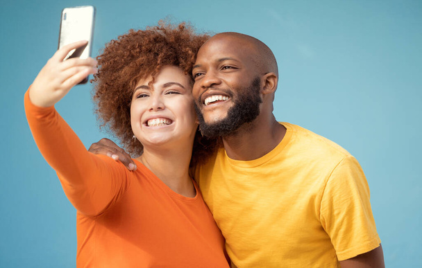 Koppel, knuffel of hechting selfie op blauwe achtergrond, geïsoleerde mockup of muur mock up voor sociale media. glimlach, gelukkig of zwart man en afro vrouw op fotografie technologie voor interraciale profielfoto. - Foto, afbeelding