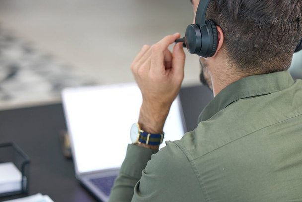 Telemarketing, business and man with headphones, call center or tech support with communication. Male person, consultant or employee with a headset, customer service or help desk with sales or laptop. - Photo, Image