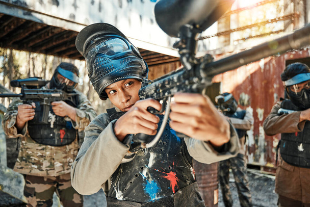 Paintball team, gun and woman aim, focus and shooting at target practice, competition or military conflict, fight or mission. Group, soldier or people point weapon in survival war, training or battle. - Photo, Image