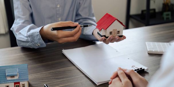 不動産エージェントは,契約に署名する前に家についての不動産保険とセキュリティの概念をクライアントに説明します.. - 写真・画像
