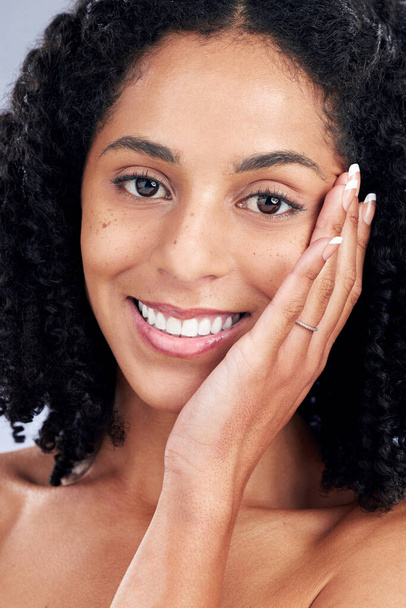 Ομορφιά, δέρμα και χαμόγελο πορτρέτο μιας γυναίκας με τα χέρια στο πρόσωπο για δερματολογία, καλλυντικά και μακιγιάζ. Κλείσιμο ενός φυσικού αφρικανικού γυναικείου μοντέλου στο στούντιο για περιποίηση προσώπου, λάμψη και απαλό άγγιγμα. - Φωτογραφία, εικόνα
